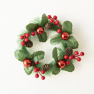 Christmas wreath with green pine needles, red berries and pine cones on white background