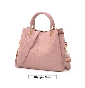 Close-up of pink faux-crocodile embossed texture and gold hardware on ladies handbag