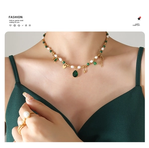 Detail of vintage style necklace with white pearls and green water-drop pendant