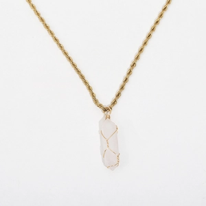 Macro view of a hexagonal pink crystal pendant with gold rope chain and wire wrap detail