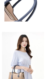 Detail of beige textured leather tote bag with blue handles and elegant script logo