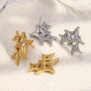 Macro shot of 18K gold and silver four-pointed star stud earrings with zircon inlay