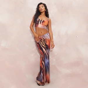 Detail of the high-waisted slim maxi skirt and crop top with abstract orange print