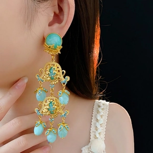 Vintage palace style gold hollow flower earrings with turquoise beads on model
