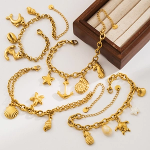 Detail of gold nautical charms including starfish and shells on a steel bracelet