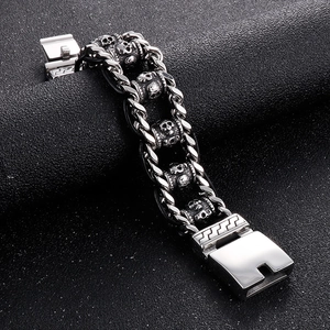 Vintage punk stainless steel skull bracelet with Cuban link chain on black background