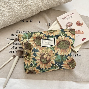 Close-up of woven jacquard cosmetic bag with yellow sunflower patterns and zipper