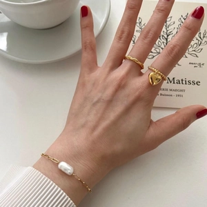 Elegant 925 sterling silver gold heart ring and baroque pearl bracelet set on a white desk