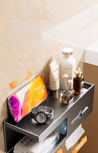 Close-up of wall-mounted dark gray bathroom organizer with smartphone and skincare items