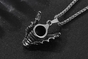 Gros plan d'un pendentif tête de dragon noir en acier inoxydable avec détails d'écailles