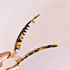 Close-up of tortoiseshell acetate hair claw showing polished finish and inner teeth