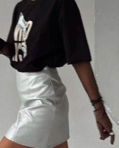 Détail d'un t-shirt graphique noir avec jupe métallisée pour un look street style tendance