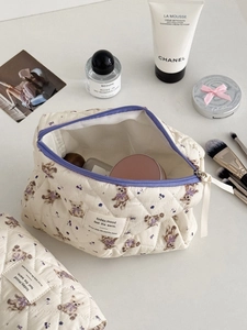Detailed close-up of quilted cotton cosmetic bag with purple bear and floral patterns