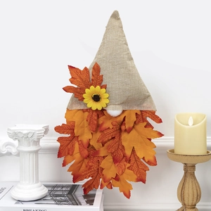 Detail of harvest gnome wall hanging with maple leaves and sunflower for autumn decor