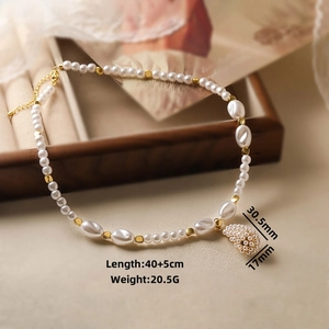 Baroque pearl necklace with gold beads and woven pearl sphere pendant detail