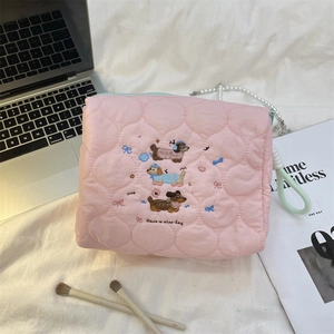 Detailed embroidery of cute dogs on quilted pink cosmetic bag with rope handle