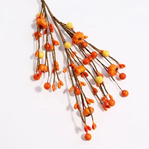Detail of orange faux pumpkins and autumn berry branches for harvest home decoration