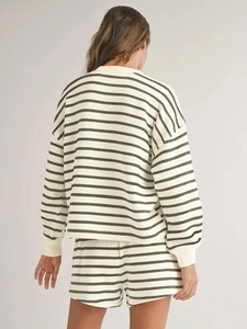 Back view of woman wearing cream and green striped long sleeve tee and shorts set
