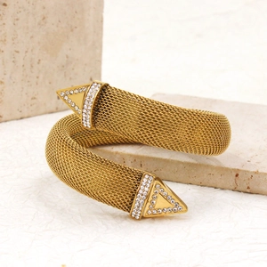 Detailed macro of gold mesh cuff bracelet with sparkling crystal triangular tips