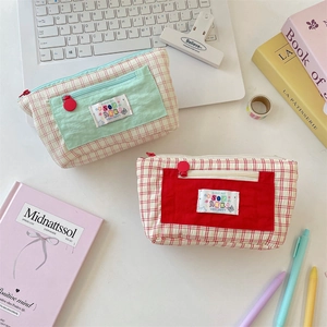 Detail of vibrant plaid pencil cases with textured bubble fabric and front pockets