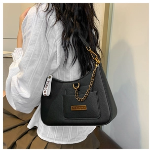 Detail of black Saffiano leather underarm bag with gold logo plate and chain strap