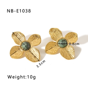Gros plan sur des boucles d'oreilles papillon dorées avec pierre verte et dimensions
