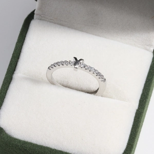 Macro shot of a silver letter Y ring with small crystals in a green velvet box