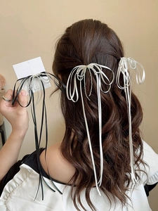 Detailed view of elegant silver ribbon bow hair clips with shimmering long tassels on hair