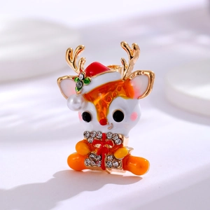 Close-up of Christmas reindeer brooch with white enamel, red hat and pearl detail