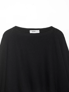 Detailed view of the round neckline and knitted texture of a black puff sleeve sweater