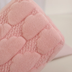 Close-up of pink quilted fleece makeup bag with heart pattern and soft texture