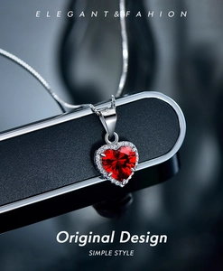 Close-up of S925 sterling silver heart necklace with red zircon and halo design