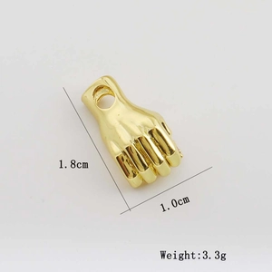 Macro shot showing dimensions 1.8cm by 1.0cm and weight 3.3g of gold fist pendant