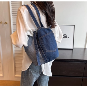 Close-up of deconstructed denim bucket bag with yellow stitching and jeans pocket details