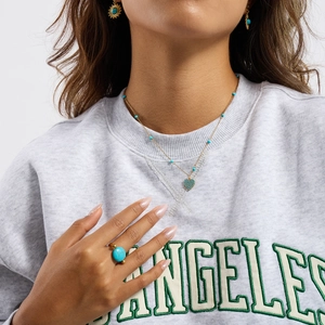 Detail of blue natural stone heart pendant necklace and earrings on a fashion model