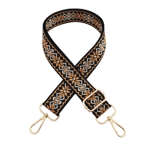 Close-up of bohemian geometric woven shoulder strap with shiny gold swivel hooks