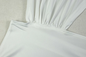 Detailed close-up of white ruched fabric with precise double-needle stitching on the dress