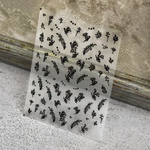 Macro detail of black 3D embossed nail stickers featuring intricate vine and leaf patterns