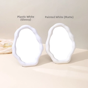 Detail of minimalist cloud-shaped vanity mirrors in glossy and matte white finishes