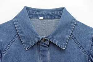 Detail of classic denim shirt collar with blue cotton fabric texture and precise stitching