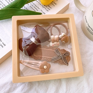 5-piece brown fabric bow hair clip and elastic hair tie set in a clear gift display box