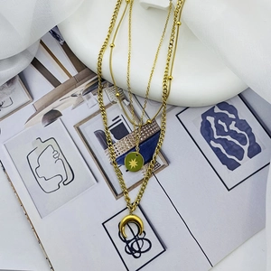 Detail of gold multilayer necklace featuring star and crescent moon pendants with metallic luster