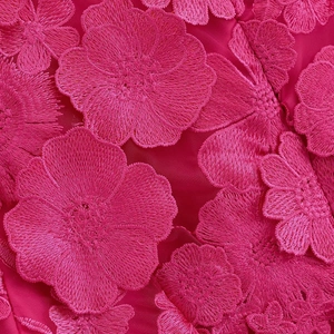 Détail de broderie florale 3D sur robe magenta à col en V avec texture en maille