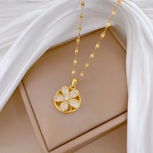 Rotating five-petal flower necklace in gold with sparkling crystals on silk fabric