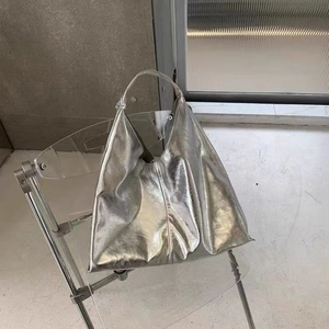 Sac hobo argenté métallisé en PU souple avec texture plissée sur chaise design