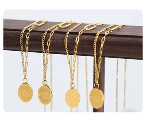 Detail of gold plated double layer necklace featuring Good Luck engraved oval pendant