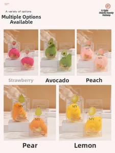 Detail showing fruit-themed makeup sponge set in transparent gift boxes with peach and lemon