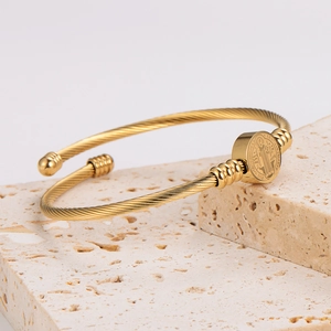 Gold stainless steel woven open bangle with Saint Benedict medal on stone base