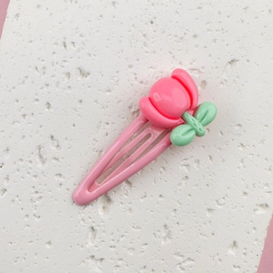 Detailed close-up of a cute 3D pink tulip flower hair clip for girls on a beige surface