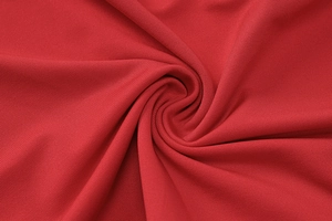 Macro della trama del tessuto a maglia rosso che mostra il drappeggio e i dettagli a spirale